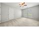 This bedroom features neutral walls, carpet, a ceiling fan, and two windows at 4507 Mackinac St, Charlotte, NC 28269