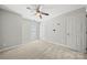 This bedroom features neutral walls, carpet, a ceiling fan, and a glass paneled door at 4507 Mackinac St, Charlotte, NC 28269