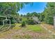 An overgrown backyard showcasing the exterior of the home with covered porches and landscaping at 4905 Grassy Creek Rd, Denver, NC 28037