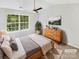 Serene main bedroom features a large window, ceiling fan, and stylish decor at 5163 Ficus Tree Ln, Charlotte, NC 28215