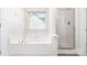 Modern bathroom with a soaking tub and a glass-enclosed shower, complemented by a neutral color palette at 5233 Halverson Ct, Kannapolis, NC 28083