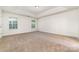 Spacious carpeted bedroom featuring tray ceiling detail and bright natural light from two windows at 5233 Halverson Ct, Kannapolis, NC 28083