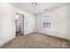 Cozy bedroom features soft carpet, natural light from the window, and a view into the ensuite bathroom at 5233 Halverson Ct, Kannapolis, NC 28083
