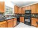 Practical kitchen featuring wood cabinets, black appliances, and black granite countertops at 5233 Halverson Ct, Kannapolis, NC 28083