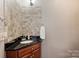 Bathroom with a dark vanity, tiled backsplash and dark countertop at 6309 Chamar Cir, Kannapolis, NC 28081