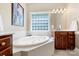 Spacious bathroom with a soaking tub, tile surround, and a bright window at 6309 Chamar Cir, Kannapolis, NC 28081