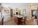 Open concept kitchen with wood floors, granite island with seating, and views to the living and dining area at 6309 Chamar Cir, Kannapolis, NC 28081