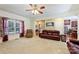 Open-concept living room with neutral carpet, large windows, and access to the kitchen at 6309 Chamar Cir, Kannapolis, NC 28081