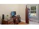 A home office with a wooden desk, chair, bookcase, and view of the pool outside the window at 6309 Chamar Cir, Kannapolis, NC 28081