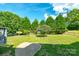 A grassy backyard with mature trees provides privacy and space for recreation at 7737 Pleasant Valley Dr, Harrisburg, NC 28075