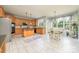 Open eat-in kitchen includes a center island, stainless appliances, and white tile floors at 7737 Pleasant Valley Dr, Harrisburg, NC 28075