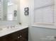 Well-lit half bathroom featuring a vanity sink and neutral wall coloring at 8918 Cotton Press Rd, Charlotte, NC 28277