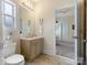 Cozy bathroom features a single vanity, tiled floor, and ample lighting at 8918 Cotton Press Rd, Charlotte, NC 28277