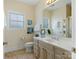 Well-lit bathroom with a single sink vanity and decorative art on the walls at 8918 Cotton Press Rd, Charlotte, NC 28277
