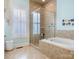 Luxurious bathroom showcasing a glass shower, soaking tub, and tile surround at 8918 Cotton Press Rd, Charlotte, NC 28277