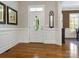 Elegant foyer with hardwood floors, wainscoting, and an oval-windowed front door at 8918 Cotton Press Rd, Charlotte, NC 28277
