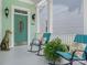 Inviting front porch with rocking chairs, a decorative dog statue, and a welcoming oval-windowed front door at 8918 Cotton Press Rd, Charlotte, NC 28277