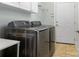Modern laundry room with stainless steel washer and dryer units and white cabinets at 8918 Cotton Press Rd, Charlotte, NC 28277