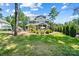 A serene backyard showcasing a blue home, lush green lawn, mature trees, pool and outdoor seating area at 101 Cross Current Ln, Belmont, NC 28012