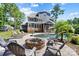 Spacious backyard featuring a pool, fire pit with seating, and a charming blue home with screened in porch at 101 Cross Current Ln, Belmont, NC 28012
