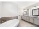 Bathroom featuring a large soaking tub, stone countertops, and custom grey cabinetry at 101 Cross Current Ln, Belmont, NC 28012