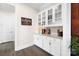 Butlers pantry with white cabinets, granite countertops, and glass display shelving at 101 Cross Current Ln, Belmont, NC 28012
