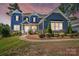 Charming two-story home featuring a covered porch, manicured landscaping, and a beautiful blue exterior at 101 Cross Current Ln, Belmont, NC 28012