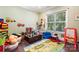 Bright playroom with hardwood floors, large window, and an array of toys and play equipment at 101 Cross Current Ln, Belmont, NC 28012