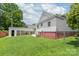 The exterior shows the white home with a carport and a green yard enclosed with a fence at 1113 W 4Th Ave, Gastonia, NC 28052