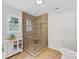 Modern bathroom with a glass-enclosed shower, tiled floor, and a white cabinet for linen storage at 1119 Holleybank Dr, Matthews, NC 28105