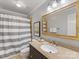 Elegant bathroom with a granite countertop, dark vanity, and shower featuring a gray and white striped curtain at 1119 Holleybank Dr, Matthews, NC 28105