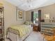 Comfortable bedroom with a single bed, floral artwork, a wicker chair, and natural light from the window at 1119 Holleybank Dr, Matthews, NC 28105