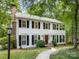 Charming two-story home with black shutters, a brick chimney, and a stone walkway leading to the front door at 1119 Holleybank Dr, Matthews, NC 28105