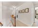 Upstairs hallway featuring wood railing, neutral carpet, and picture frame molding at 1119 Holleybank Dr, Matthews, NC 28105