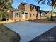 This two-story home features dark siding, black shutters, and a long driveway at 112 Gilliatt St # 1, Shelby, NC 28150