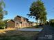 This two-story home features dark siding, black shutters, and a long driveway at 112 Gilliatt St # 1, Shelby, NC 28150