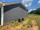 Side view of the house showing gray siding and the two HVAC units on a partial sunny day at 118 Still Creek Dr, Mooresville, NC 28115