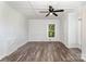 Open bedroom with modern ceiling fan, window and vinyl floors at 1224 Hollywood Ter, Albemarle, NC 28001