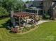 Outdoor kitchen with stone fireplace surrounded by landscaping and green grass at 1377 Shinnecock Ln, Fort Mill, SC 29707