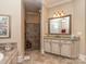 Bright bathroom with double vanity, granite countertops, and tiled shower at 1377 Shinnecock Ln, Fort Mill, SC 29707