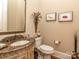 Well-appointed half bath featuring decorative sink, toilet, and wall decor creates a stylish and functional space at 1377 Shinnecock Ln, Fort Mill, SC 29707