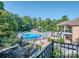 Inviting swimming pool area with ample lounge chairs, a waterslide, and surrounding mature trees at 1377 Shinnecock Ln, Fort Mill, SC 29707