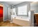 Bright bathroom with a large soaking tub and separate glass enclosed shower at 13916 Mallard Lake Rd, Charlotte, NC 28262