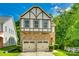 Charming two-story home with a stone-clad facade and a two-car garage, set against a bright blue sky at 13916 Mallard Lake Rd, Charlotte, NC 28262