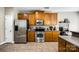 Kitchen with stainless steel refrigerator, oven, and microwave, complimented by wood cabinetry and tile floors at 13916 Mallard Lake Rd, Charlotte, NC 28262