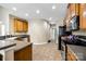 Functional kitchen with warm wood cabinets, tiled flooring, and stainless steel appliances at 13916 Mallard Lake Rd, Charlotte, NC 28262