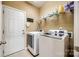 Bright laundry room with side-by-side washer and dryer and shelving for storage at 13916 Mallard Lake Rd, Charlotte, NC 28262