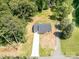 Aerial view of new construction home with long concrete driveway surrounded by greenery at 157 Fraley Rd, Gastonia, NC 28052