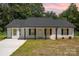 Charming one-story home with a well-maintained lawn, contrasting black shutters, and a paved driveway at 157 Fraley Rd, Gastonia, NC 28052