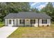 Charming one-story home with a well-maintained lawn, contrasting black shutters, and a paved driveway at 157 Fraley Rd, Gastonia, NC 28052